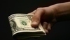 Fotografie ruky, která drží americké bankovky