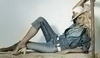 Karolína Kurková v džínovém oblečení s kloboukem na hlavě ležící na dřevěné desce