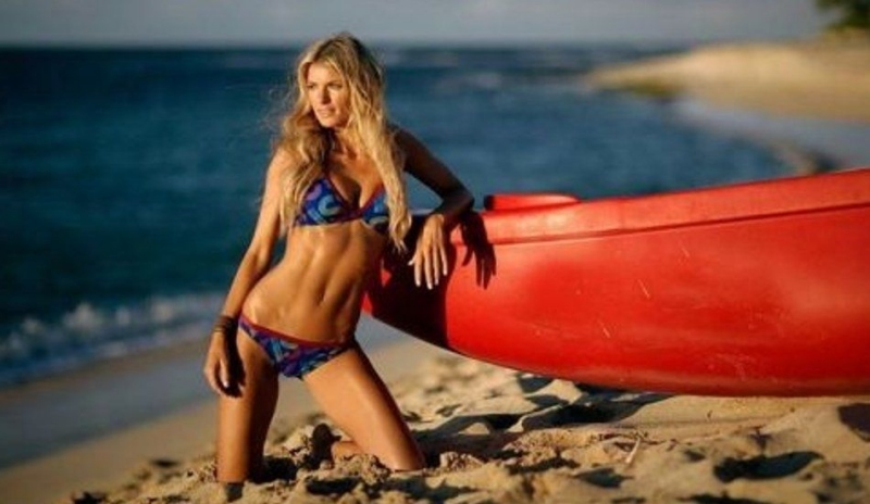 Marisa Miller v plavkách na písčité pláži opírající se o člun