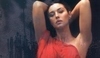 Monica Bellucci v sexy červených šatech na tmavém pozadí