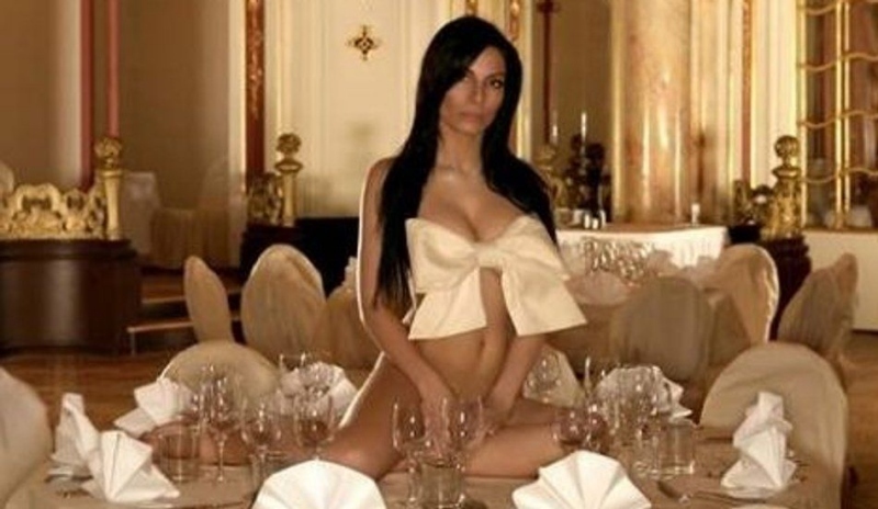 Eva Aichmajerová sedící na stole mezi skleničkami