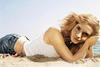 Emma Watson leží na písku s rukama pod hlavou