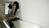 Amy Winehause sedí na vaně