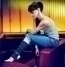 Šárka Vaňková sedící v džínách a triku na fialové pohovce