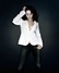 Melanie C v džínách a bílém saku na tmavém pozadí