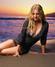 Drew Barrymore sedí na pláži u moře