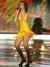 Kamila Nývltová ve žlutých tanečních šatech s mikrofonem v ruce
