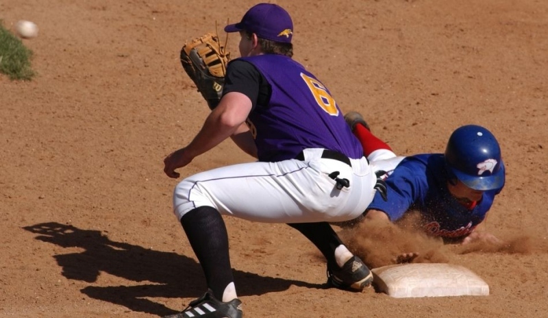 Foto zobrazující hráče baseballu. Na metu se dá doběhnout, doklouzat s nohama napřed i dojet po břichu