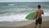 Fotografie muže se surfem v ruce čekající na vlnu