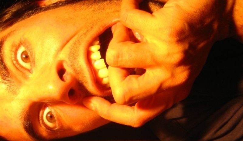 Fotografie muže kousajícího si prsty