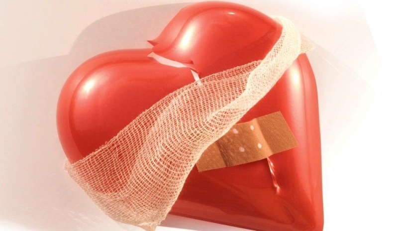 Snímek červeného srdce s náplastí a obvazem