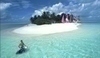 Fotografie zobrazující ostrov a muže se surfem