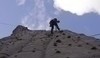 Muž šplhající na vrchol hory