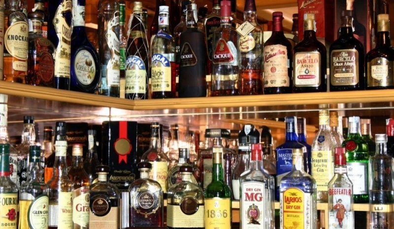 Fotografie zobrazující láhve s alkoholem na polici