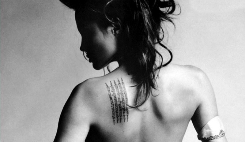 Fotografie ženy s tetováním na zádech