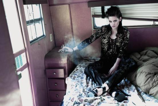 Kristen Stewart sedí oblečená na posteli