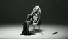 Černobílý obrázek ženy sedící na židli