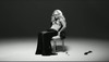 Černobílá fotografie blondýny sedící na židli