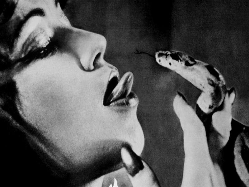Žena s vyplazeným jazykem drží u pusy hada