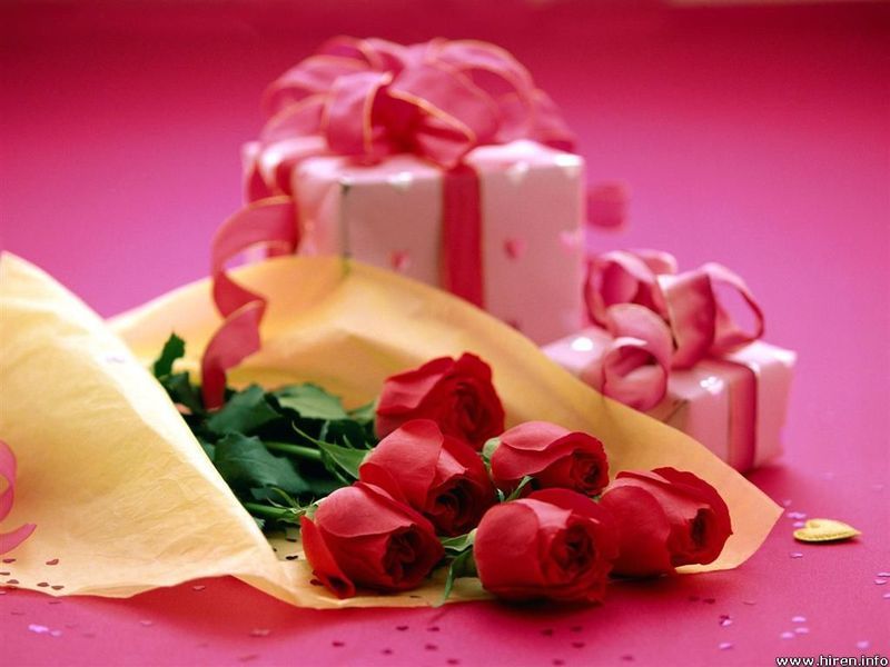 Fotografie kytice červených růží a dvou krabiček s mašlí
