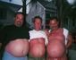 Fotografie tří mužu odhalujících své pivní pupky