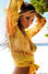 Fotografie ženy ve žluté halence stojící v písku