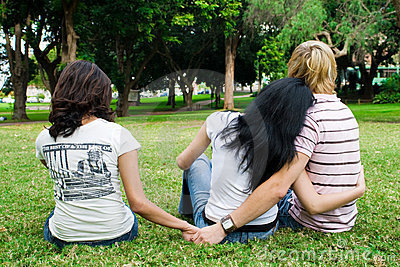 Fotografie tří mladých lidí sedících na trávě