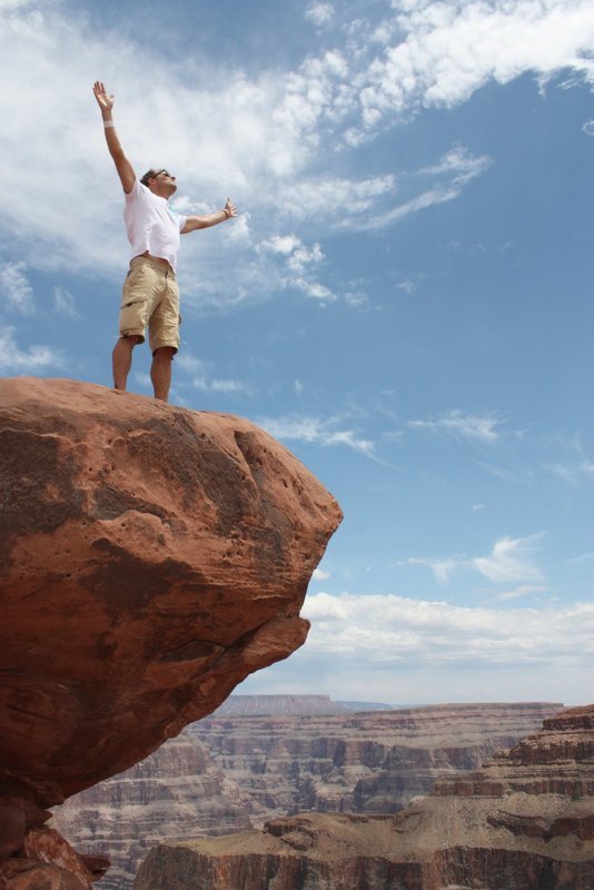 Muž stojící na skále v Grand Canyonu