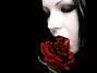 Fotografie ženské tváře s červenou růží u pusy