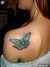 Snímek ženy s tetováním motýla na rameni