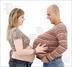 Fotografie těhotné ženy a muže zkoušejícího těhotenství